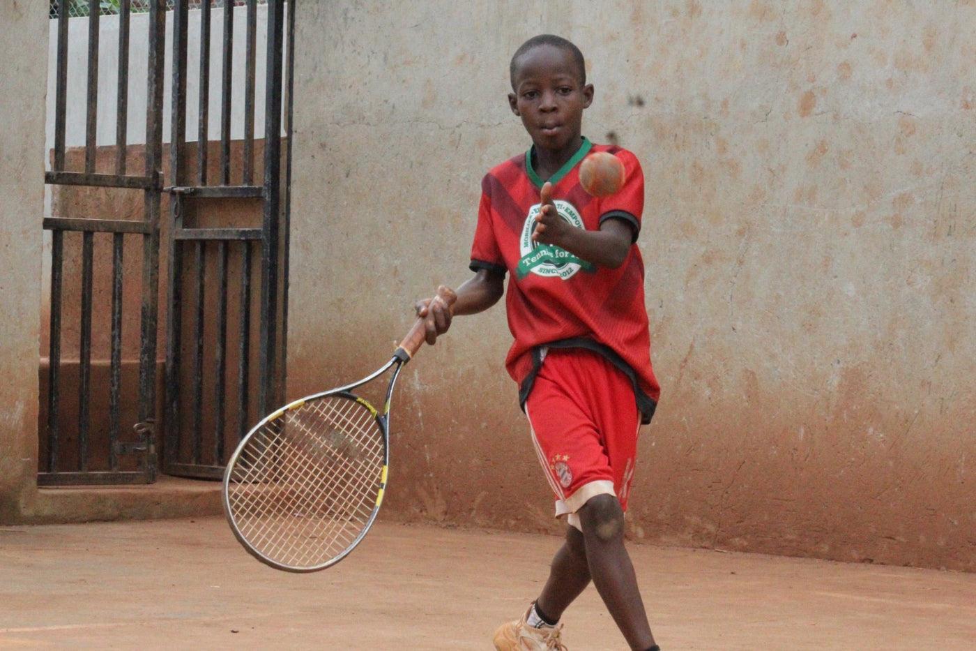 Young Tennis For All participant playing tennis in Uganda